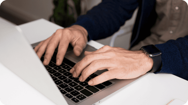 Mãos masculinas digitando em um notebook