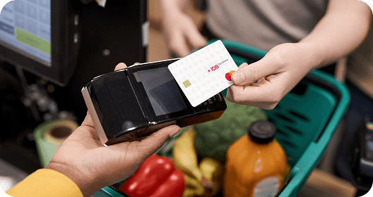 mulher passando o cartão IOB Benefícios no caixa do mercado